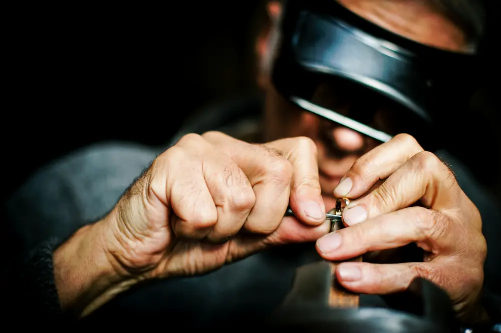 A jeweler holding a ring close and examining it by hand