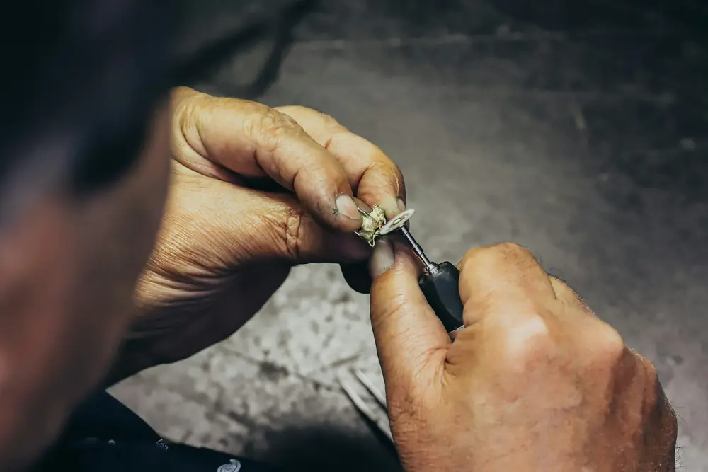 A jeweler setting a stone in a ring at the bench