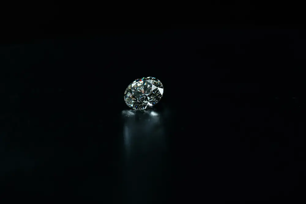 A single round brilliant diamond on a black ground
