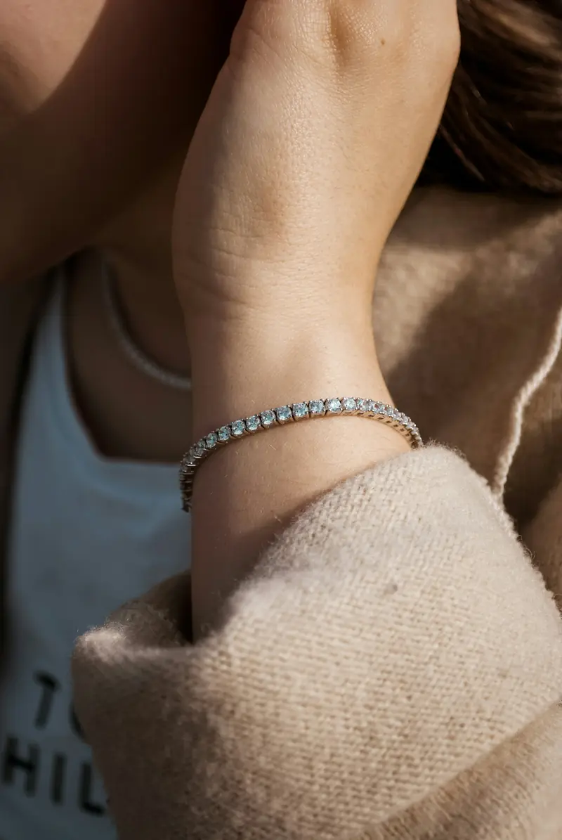 A diamond tennis bracelet worn on a wrist