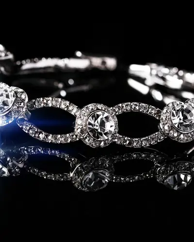 Close view of a diamond link bracelet with pavé links and bezel-set round diamonds, on a black ground