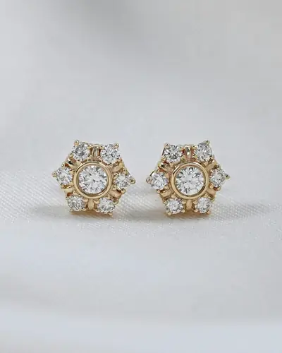 A pair of hexagon shaped diamond cluster stud earrings on a white ground