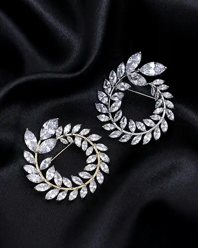 A pair of open wreath earrings set with marquise and round diamonds on black satin